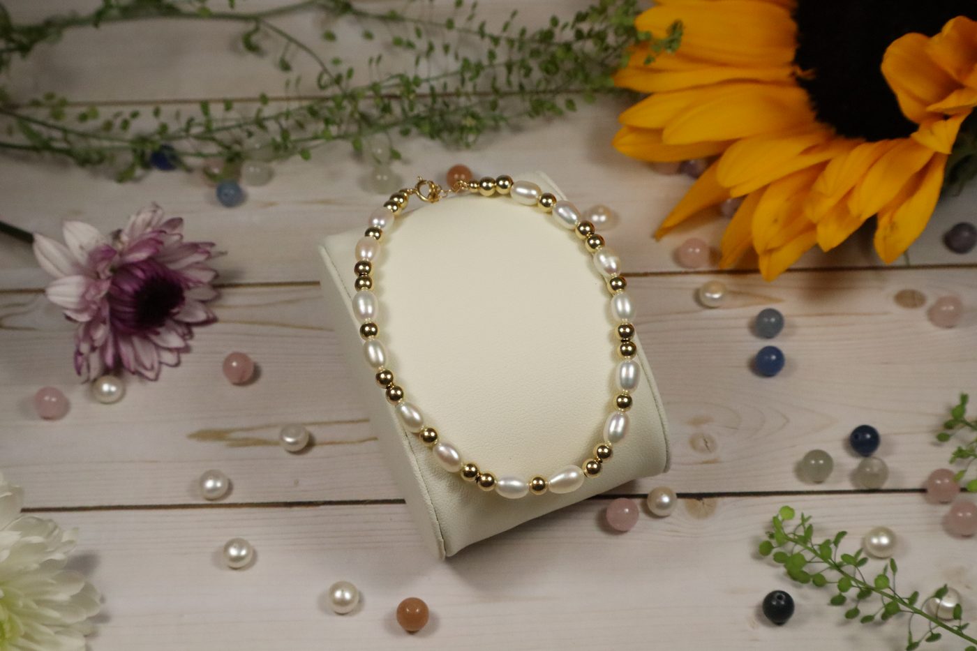 Freshwater pearl and gold-filled bead bracelet on a cream jewelry display stand